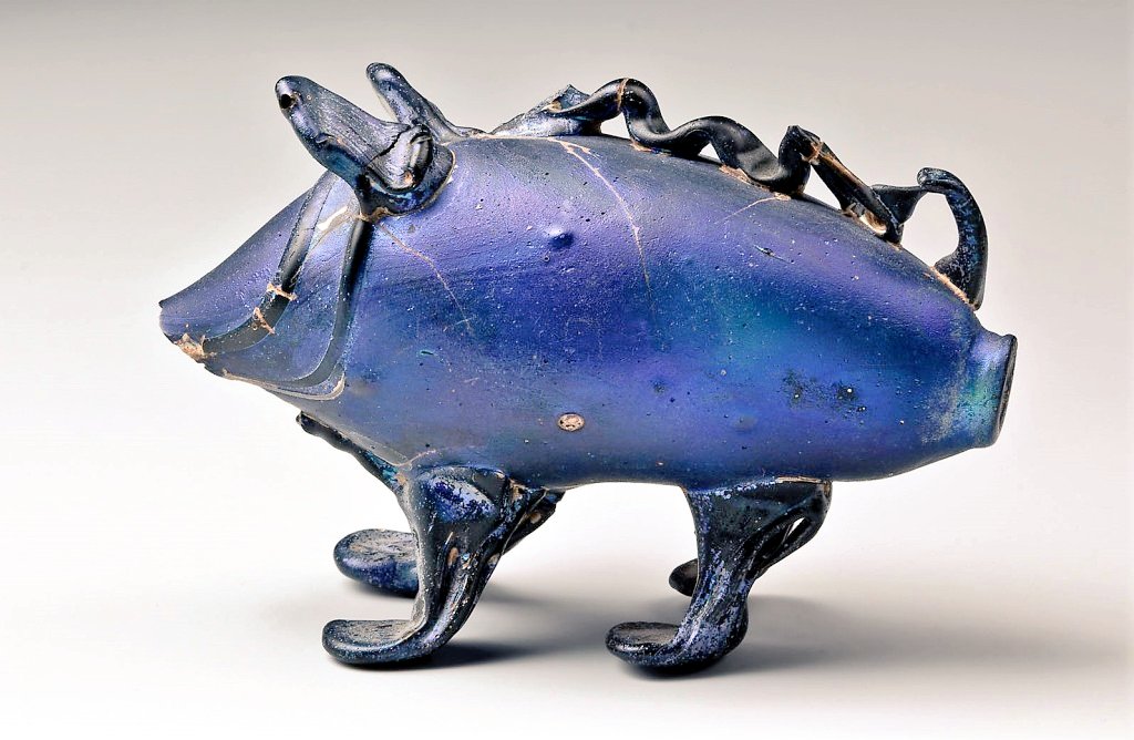 DrNWillburger's tweet photo. One of my most favourite #glass vessels: A marvellous #Roman vessel in the form of a #pig, made of blue glass. It was used to hold ointment or perfume. 
Found in a burial in Cologne. Dating late 2nd/early 3rd c. AD

Photo: Römisch-Germanisches Museum Köln 

#RomanArchaeology https://t.co/bcvwBs0LjC