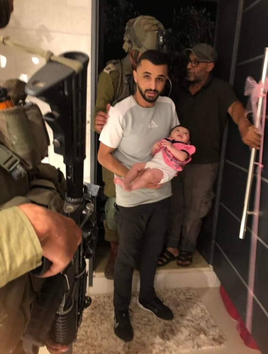 Palestinian father holds his baby for the last time before being detained by the lsraeli occupation forces
