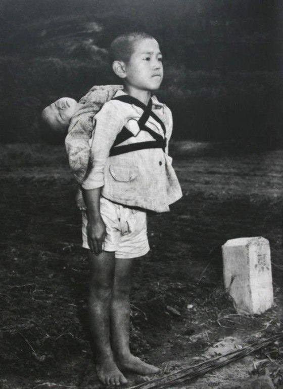 Un niño japonés lleva a la cremación el cuerpo de su hermano menor después de un ataque. La foto se convirtió en un símbolo de la inhumanidad de los ataques atómicos estadounidenses en Hiroshima y Nagasaki. EEUU sigue siendo el único país en usar esas armas. No olvidamos. 🌹