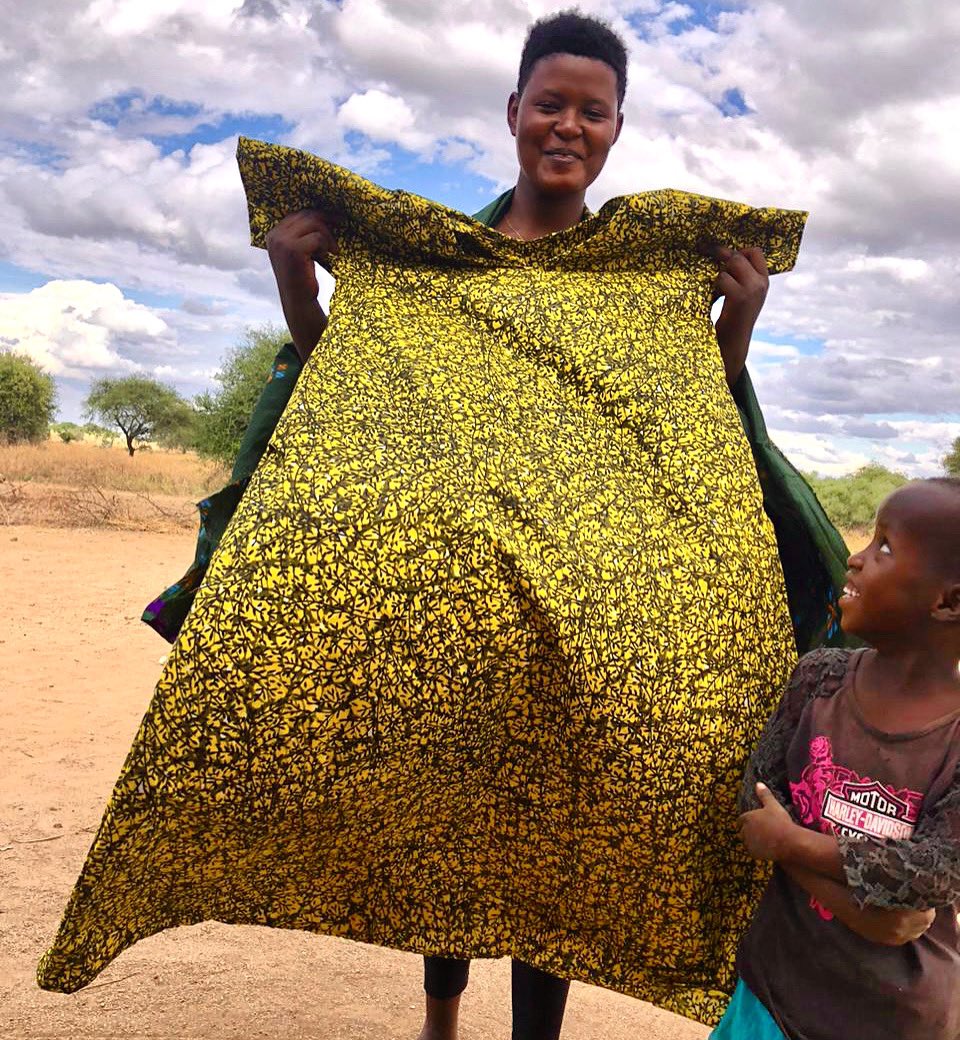 Jacqueline proudly shows off a dress that she has sewn, while a little one looks on with admiration💚 #investingirls #maasai #indigenous #sisalfoundation