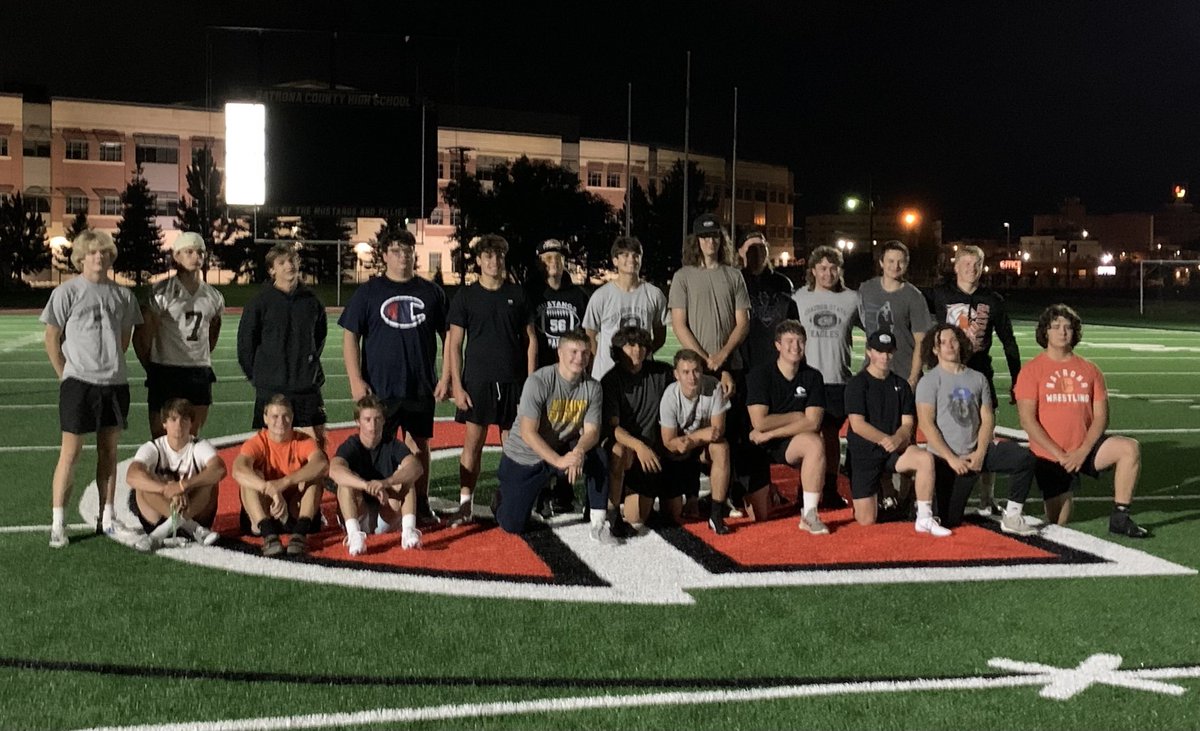 WyoVarsity's tweet image. The 2023 ⁦@NatronaFootball⁩ seniors pose for a photo at midfield after their Midnight Madness practice.