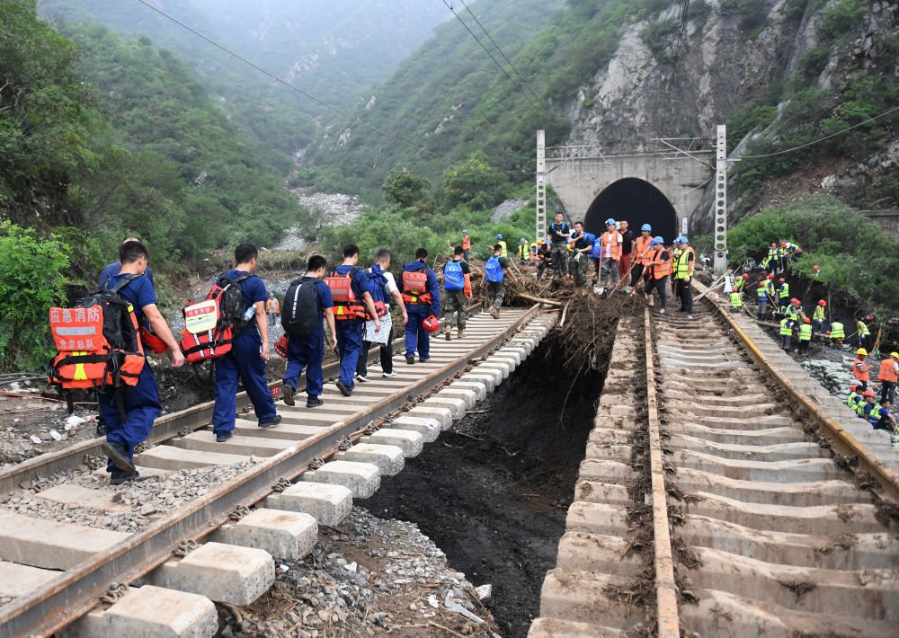 这张照片可以看出这次北京暴雨山洪的威力之大，这铁路下方的路基整个给冲没了，楞冲出一条河道来。