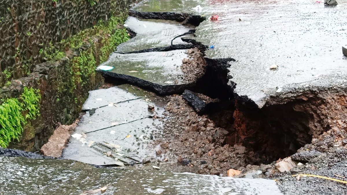 gallilivenews's tweet photo. The wall of #ITPark's major #nullah in #Goregaon collapsed late Monday night, causing the road to #crackopen. 

A #parkedtruck was #trapped as the #roadcaved in, requiring a #crane to be brought in for its #rescue.  

#Goregaon #RoadCollapse #Mumbai #HeavyRains #Heavyrainfall https://t.co/MmQH8msDtT
