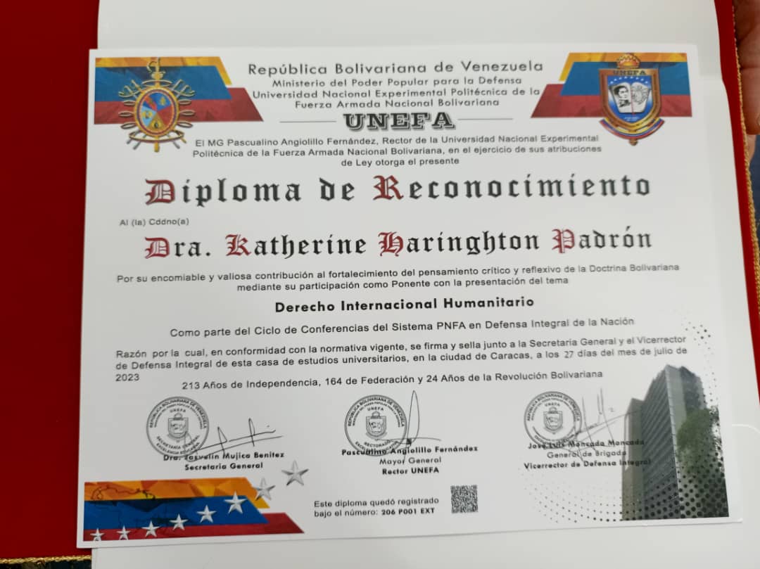 Unefa_VEN's tweet photo. El Rector de Nuestra Casa de Estudios, MG @angiolillofp, hace entrega del Diploma de Reconocimiento a la Dra, Katherine Haringhton Padrón. Mediante su participación como ponente en la presentación del tema Derecho Internacional Humanitario. https://t.co/w06VAnnn2E
