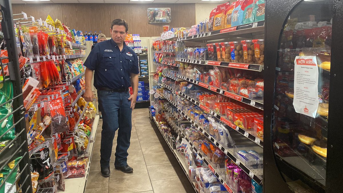 JakeMRosen's tweet photo. 📸 Gov. Ron DeSantis weighs his options in the snack aisle at a Casey’s in Eddyville, Iowa @CBSNews 

(He settled on a Quest bar) https://t.co/SUjGMgp3U9
