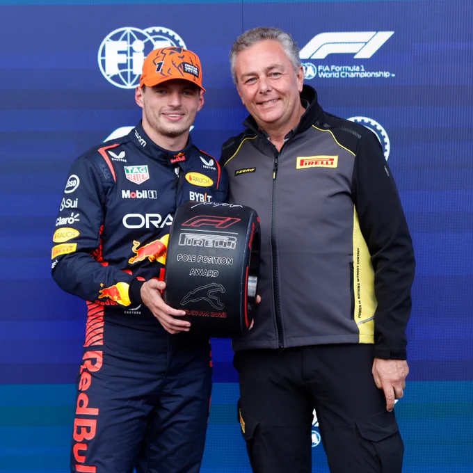 Max Verstappen holds up the Pirelli Pole Position Award tyre for the 2023 Belgian Grand Prix, as Mario Isola stands alongisde him.