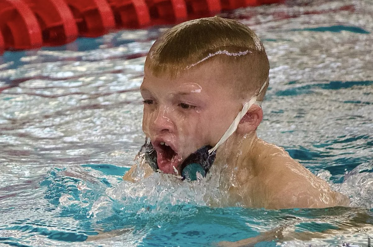 True Grit #WhateverItTakes #DoItAnyway #DoItWell #DoYourBest photo ID: Jack running, with a big smile, a race with one shoe on a street, losing the shoe halfway through the race. Jacen swimming with no goggles earning a divisional cut time.