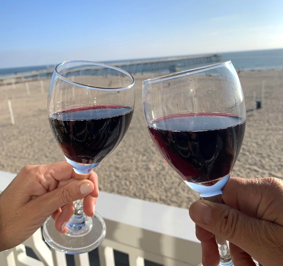 BeachHouseHotel's tweet photo. Unwind and clink your glasses in style on one of our ocean view porches, where every sip pairs harmoniously with a beautiful Hermosa shoreline backdrop.

#imageDescription: A couple of hands 'cheers' their glasses of red wine on the porch overlooking the Hermosa Beach shoreline. https://t.co/OFX6jftS7e