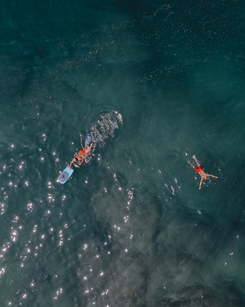 Two men swimming as they are escaping the heat wave and high temperature
