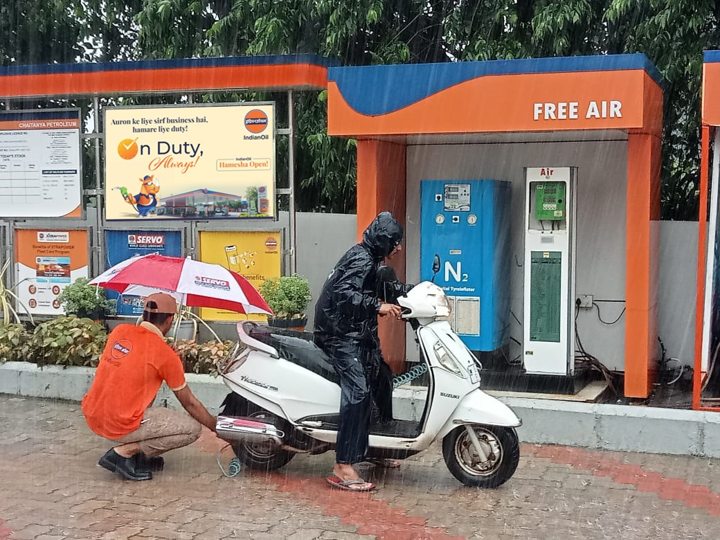 Committed customer service at #IndianOil Retail Outlet. Customer attendant filling air during incessant  rains ~ M/s Chaitanya Petroleum in Goa.#On duty always #Nation first #IndianOil cares #Travel with IndianOil