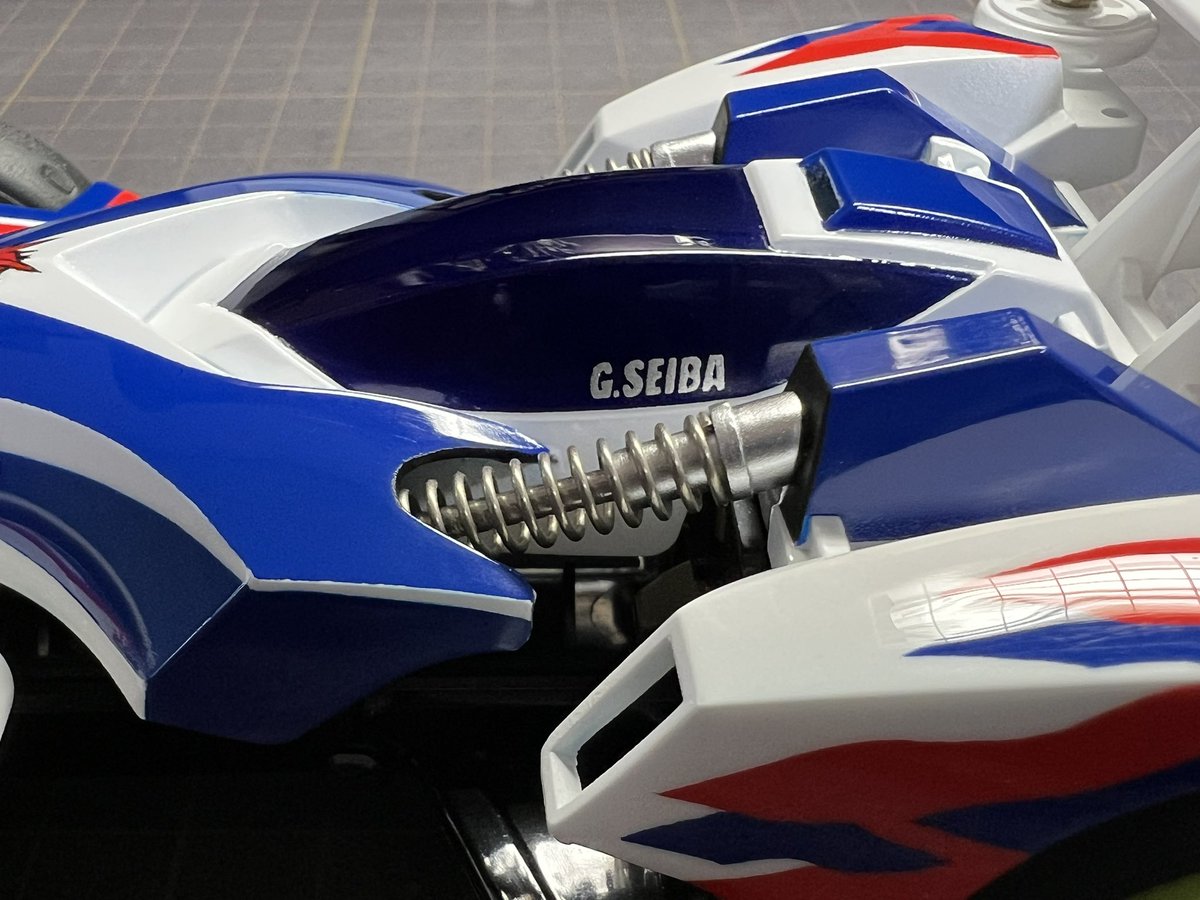 mini4wd_Q's tweet photo. アニメ版 ビートマグナム TRFビクトリーズ仕様 完成しました！
今回も細長いバネを使って、ボディ内側まで潜り込む形状を再現、ヒンジ付きシャーシと塗装ホイールもアニメを参考に仕上げました。
やはりTZシャーシが一番しっくりきます…！
#mini4wd #ミニ四駆 #ビートマグナム https://t.co/OLy7CtraE1
