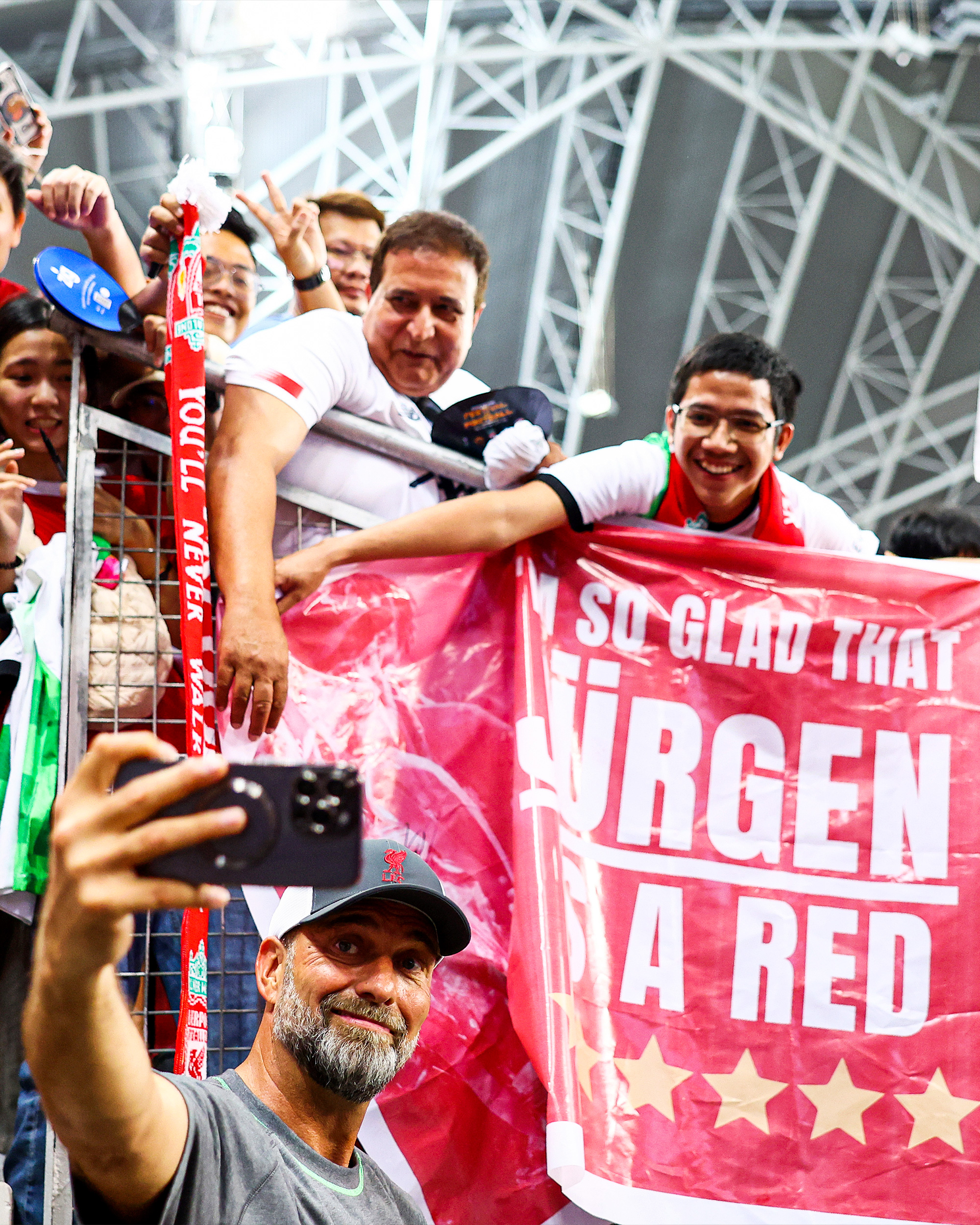 Jürgen Klopp poses for a photograph with fans that have a banner that reads "I'm so glad that Jürgen is a Red" 