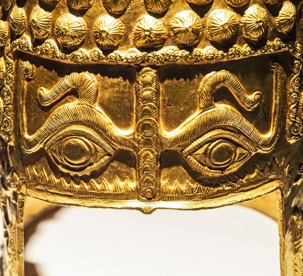 OptimoPrincipi's tweet photo. The incredible golden helmet was discovered in 1929 near the Romanian village of Coțofenești - unearthed by chance by a young local boy named Trajan. The Golden Helmet of Coțofenești is fashioned from a kilogram of solid gold, decorated with large studs on the top of the skull and two piercing apotropaic eyes, meant to ward off the evil eye and malevolent magic spells. Decorating the cheek guards are scenes of animal sacrifice, with men preparing to cut the throats of a bull and lamb with short daggers. The ceremonial helmet is thought to have belonged to an unknown local Geto-Dacian king from around the year 400 BC and offers a fascinating insight into the proto-history of the rich Dacian kingdom, destined to be conquered by the Roman emperor Trajan, 500 years later. National History Museum of Romania, Bucharest.