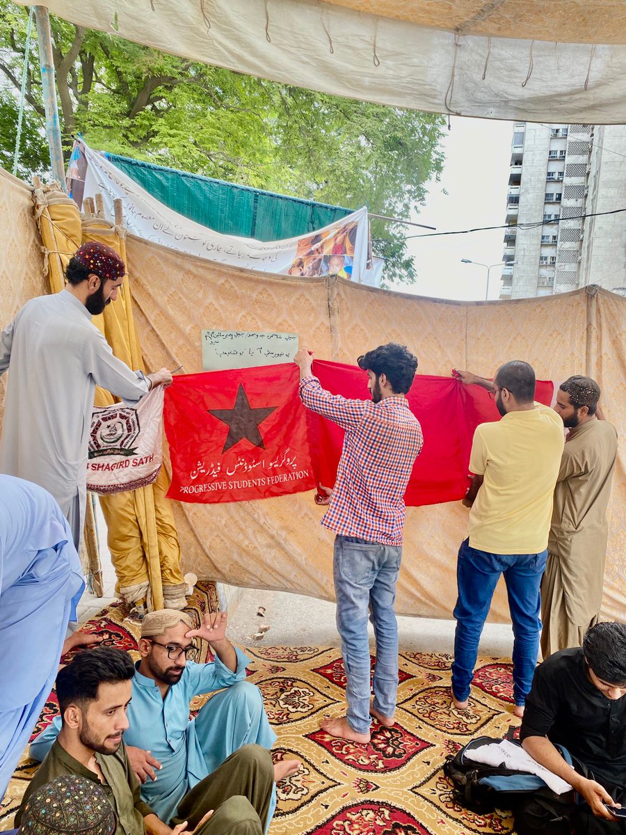 PrsfK's tweet photo. Members of PrSF hang up flags at the hunger strike camp in front of Karachi Press Club, as  students of Dawood University continue their fight for restoration of their admissions https://t.co/RStyo9jcpi
