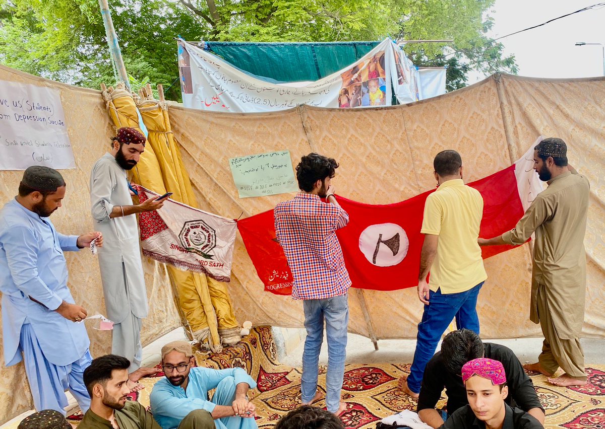 PrsfK's tweet photo. Members of PrSF hang up flags at the hunger strike camp in front of Karachi Press Club, as  students of Dawood University continue their fight for restoration of their admissions https://t.co/RStyo9jcpi