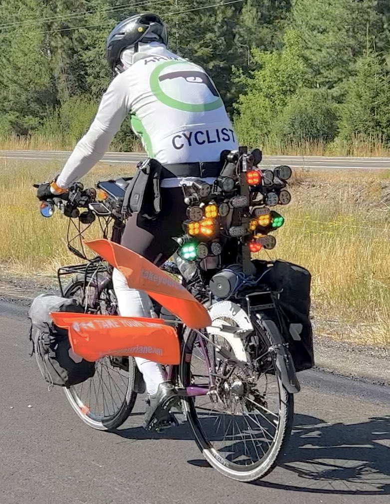 Driving home from vacay just now and see this dude riding in the shoulder of I-90 outside of Coeur d'Alene w an “Armed Cyclist” jersey, safe passing flags, dozens of taillights. Absolutely epic.