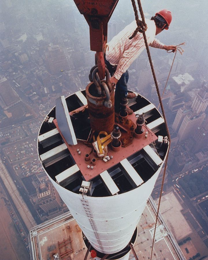 CrazyFenaker's tweet photo. Workers moving a section of the World Trade Center antenna into place in 1979. Photographed about 1700 feet above the streets of New York. https://t.co/TlqJfZcjFL