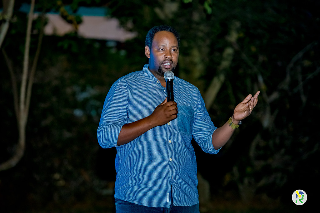 kemnique's tweet photo. Umugoroba w’Abahanzi! Ikiriyo cyo guherekeza bwa nyuma producer Junior Multisystem
Umugoroba w’Abahanzi! Ikiriyo cyo guherekeza bwa nyuma producer Junior Multisystem

Umuhango wo kwibuka Junior Multisystem wabimburiwe n’isengesho ryakozwe na Pastor Jean Baptiste wagaragaje ko imitima y’abateraniye mu ihema ryasezerewemo nyakwigendera irimo agahinda gusa ko umunsi nk'uyu wagombaga kubaho.

Umubiri wa Jean Luc Karamuka uzafatwa ejo ku wa Gatatu Saa yine za mu gitondo ku bitaro by’akarere bya Nyarugenge. Saa sita hazatangira amasengesho. Saa munani azasezerwaho bwa nyuma noneho berekeze i Rusororo saa kumi z’igicamunsi.

Umukuru w’umuryango wa Jean Luc Karamuka yakunze kumvikanisha ko uyu ari”Umugoroba w’abahanzi”.

Ijambo rya Twahirwa Aimable uhagarariye Leta muri uyu muhango,  yavuze ko kuva Junior yakora impanuka abahanzi bamubaye hafi.
Ati:”Uku gukorana kudufashe gushyira hamwe twitegure kuko turi mu Isi y’ibyago”.

Yasabye abahanzi gukomeza gutahiriza umugozi umwe bagafatanya muri byose kuko abishyize hamwe nta kibananira.

Ati:”Yatangaga indirimbo ku gihe kandi yasize inkuru nziza kuko ibihangano yakoze bitazazima”.

Abahanzi babanye mu rugendo rw’umuziki kuva mu 2009 kugeza mu 2023, baje kumuherekeza bwa nyuma barimo Riderman, Butera Knowless, King James, Tom Close n’umufasha we, Tonzi, Bruce Melodie n’abandi.

Mu myidagaduro kandi mu ngeri zitandukanye hari abanyamakuru bafite amazina nka Luckman Nzeyimana ukorera Ikigo cy’igihugu cy’itangazamakuru, Basile Uwimana, Uncle Austin, Ally Soudy n’abandi.

Ababanye bya hafi nka Kjohn wagize uruhare mu bijyanye no kumenyekanisha muzika nyarwanda, Zizou Alpacino wabanye bya hafi na Junior Multisystem nawe yari ahari.

Umunyamakuru Khamis Sango ukorera Televiziyo na Radio 10 niwe wahaye ikaze abaje guherekeza bwa nyuma Junior ndetse n’icyegeranyo kigaruka ku mateka ya Junior Multisystem mu ijwi ryiza riremereye.

Mama wa Junior, Karamuka Jeannine mu cyegeranyo kigufi yavuzeko yaranzwe no kwisekera ubuzima bwe bwose.

Ubuhamya bugufi burimo ibyamuranze ariko by’umwihariko bwahurije ku kuba yaragiraga urugwiro.

Ati:”Ibintu by’umujinya ntabwo byari ibye”. 

Afite umwaka n’igice bakiri i Burundi yaguye mu mazi ababyeyi bakeka ko yatabarutse. Mama we ati:”Urupfu rwamugenzeho kuva akiri umwana. Agwa mu mazi tukiri i Burundi twari tuzi ko byarangiye. Hari n’indi mpanuka yigeze kumugera amajanja birangira ntacyo abaye.

Yavuze ko yari agiye mu isabukuru ya mushiki we agarutse akora impanuka.

Yabanje kwanga kujyayo ariko bimwanga mu nda. Mama we yashimiye Muyoboke Alex na Uncle Austin bahagobotse yabuze imbangukiragutabara imujyana CHUK. Icyo gihe baraye mu bitaro bikuru bya Kaminuza’CHUK’ babanje gusaba ko badoda ukuboko basanga igisubizo ni ukuguca.

Papa wa Junior yagiye gusinyira ko umuhungu we bamuca ukuboko. Yarwariye kwa se umuganga akajya aza kumukorera isuku. Se ati:”Yarwariye iwanjye arinda akira”.

Uncle Austin yasobanuye ko agikora impanuka yakoze ubukangurambaga kuko abahanzi bumvaga bamurimo ideni’. Ati”Na nyuma niwe wakoze mastering ya Closer yanjye na Meddy”.

Yanyweye amazi arahindukira ashiramo umwuka. Mama we yanavuze ukuntu yatinyaga serumu ku buryo ubwo bari kwa muganga yasabye mama we ko bamukuramo serumu undi akamuhakanira ko kubona umuti byabagoye.

Umuryango we uvuga ko yababereye urugero rwiza ndetse yitaga kuri bene wabo.

Junior Multisystem asize umwana nk'uko byavuzwe na mama we. Ubwo yashiragamo umwuka ntiyigeze asamba yatashye abyiyumvamo.

Umuhango irakomeje ejo abazabon