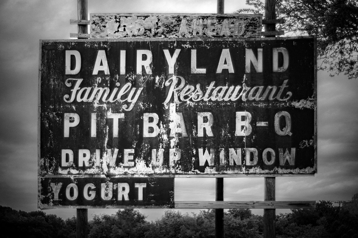 Dairyland Family Restaurant. Sign behind overgrown trees. Love Mandler deigned lenses from #leica. Go #vintage or go home…#m11  #leica #antique  #retro #sign #classic #americana
  #leicacamera #leicacam  #bnw  #bw #leicalove #blackandwhitephotography #rust  #sign <a href="/LeicaCameraUSA/">Leica Camera USA</a>