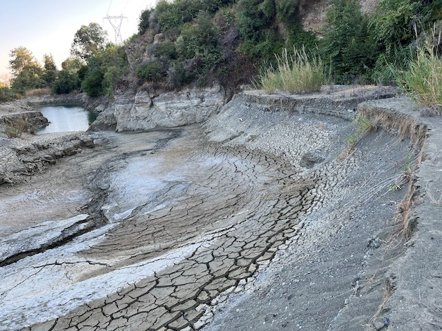 makdrou's tweet photo. Σε απόσταση μερικών χιλιομέτρων από την πυρκαγιά που μαίνεται στην επαρχία Λεμεσού βρίσκεται το φράγμα του Σαϊττά. Είναι η μοναδική δεξαμενή νερού στην ε��ρύτερη περιοχή πρόσβασιμη από τα ελικόπτερα.
Στην πυρκαγιά του 2007 σώθηκε το Τρόοδος διότι τα ελικόπτερα επιχειρούσαν από το φράγμα του Σαϊττά (φωτό) 
Σήμερα αυτή η δυνατότητα δεν υπάρχει διότι η στάθμη του φράγματος έχει κατέβει (φωτό 2) και τα φράγμα ξεράθηκε (φωτό 3). Το διεφθαρμένο σύστημα εξουσίας έχει ξεπουλήσει ΚΑΙ το νερό σε ιδιωτική επιχείρηση η οποία το μεταφέρει σε παράνομες υποδομές διασκέδασης και ψυχαγωγίας στην κοίτη του Κούρη (φωτο4), στη ζώνη προστασίας του ποταμού ΚΑΙ σε κρατική γη.
@Christodulides  @OMichaelides @CyMOApress   @DeptOfForests @CharalambosAle2