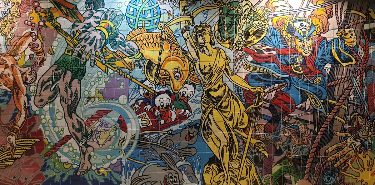 At the Oriente station of the Red Line of the Lisbon subway, there is this amazing, comic book-inspired mural, that I tried to capture fully in these two photos:
