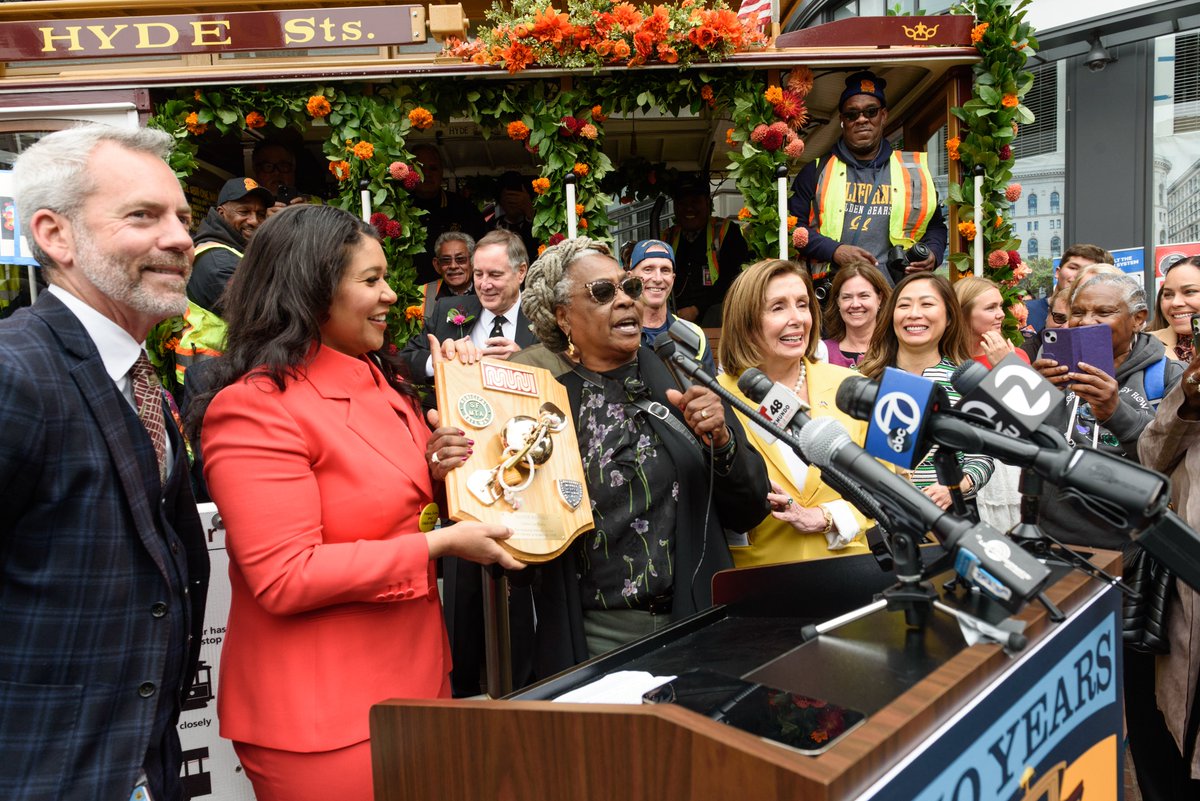 SFMTA_Muni's tweet photo. #DidYouKnow Fannie Mae Barnes (middle) was the first-ever woman cable car grip, a breakthrough she achieved 25 years ago, in 1998. Today, she was honored with the Cable Car Hero plaque as we celebrated the 150th anniversary of the world's first cable car. #CC150 https://t.co/iKQD6XmBGk