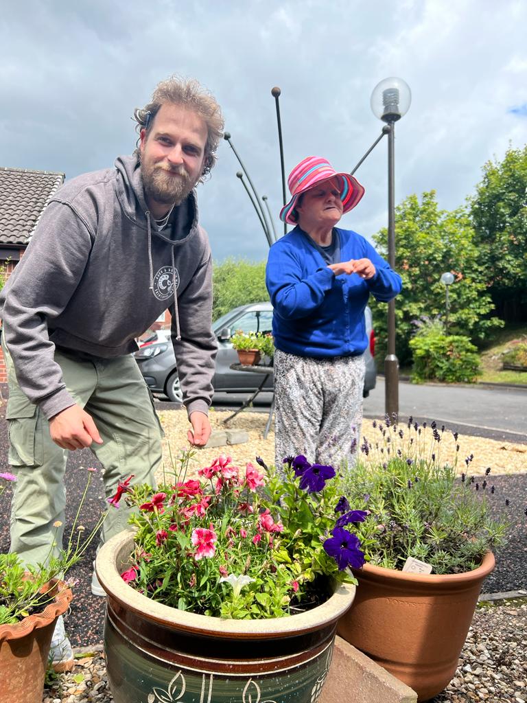 VHA_VisionHomes's tweet photo. The winners of the Kings Coronation photo competition at our 1b Toll Gate Road service won a Cadbury Dairy Milk bouquet, and one of the residents enjoyed a spot of gardening in the lull between the rain. #WinnerAnnouncement #gardening #DisabilityInclusion https://t.co/IZFJN4F5Ef