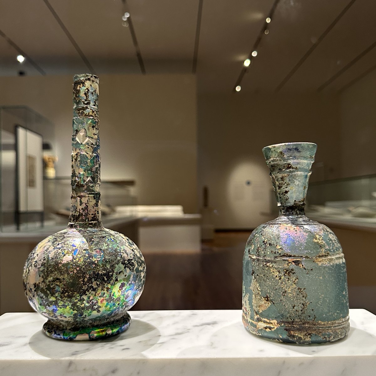AgaKhanMuseum's tweet photo. The surface iridescence on these bottles is not their original pigmentation, but rather the result of decay due to the long period the glass was buried in soil before excavation. This kind of weathering held considerable attraction to later generations of artists and collectors. https://t.co/7lcbHFIh0M