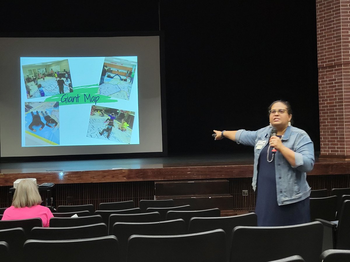 Monje Atlow presents about our new social studies instructional model at DWPL K-2 today. Thanks,  Monje! Teachers are so interested in the giant map and Indi cars 🙂