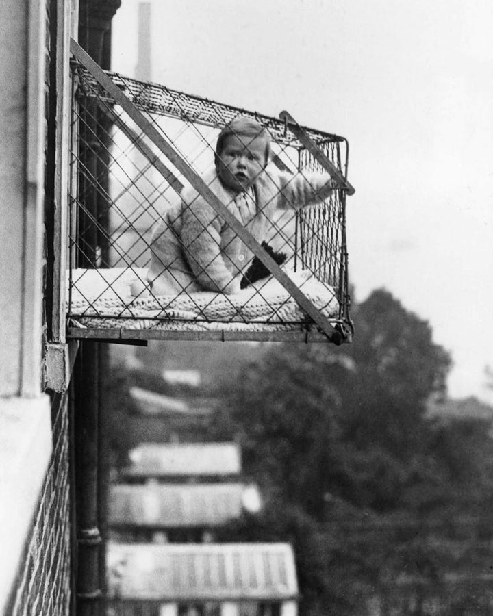 fasc1nate's tweet photo. A baby cage, initially named a "health cage", was essentially a bed encased in wire, dangling from the windows of city apartments. Mrs. Robert C Lafferty devised this concept to allow babies access to fresh air and sunlight despite living in densely populated cities.  Baby cages witnessed a surge in popularity in London during the 1930s. 

These were designed specifically for children residing in cities without access to gardens. Local community groups, such as the Chelsea Baby Club, distributed these baby cages to members without gardens. However, the start of World War 2 and the subsequent Battle of Britain led by the Luftwaffe put an end to the use of baby cages throughout London. 

Despite this, they made a comeback in 1953.  Eventually, by the mid-1900s, the demand for baby cages gradually dwindled, perhaps due to rising safety concerns and the increased traffic in urban settings.