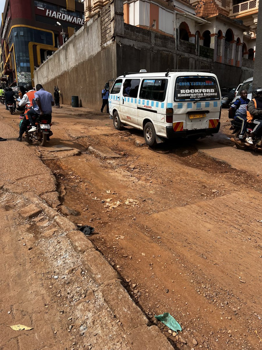 SpireJim's tweet photo. Here is the KAMPALA POTHOLE OF THE WEEK. Found near Nakasero Mosque, discovered by @LouisseniorK . It has a record of breaking 677 shock absorbers &amp; 342  bumpers. If you pass by, give it some flowers or plants. Join me in suggesting a name for it. 🎇🎊
#KampalaPotholeExhibition https://t.co/mgGQAIHSEl