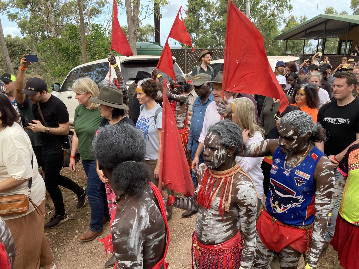 The Prime Minister being escorted by red flag dancers to the opening ceremony at Garma