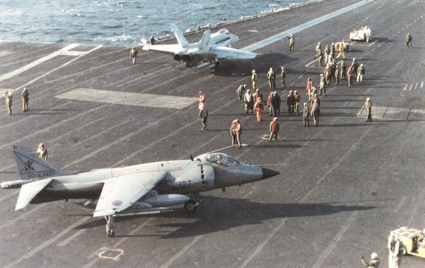 HarrierPres's tweet photo. The pilot of Seaharrier FRS.1 (possibly XZ500) from 800NAS watches as an F/18 hornet lines up for a cat shot. USS America, 1991. #800NAS #Harrierpres https://t.co/YjUoOAAZlc