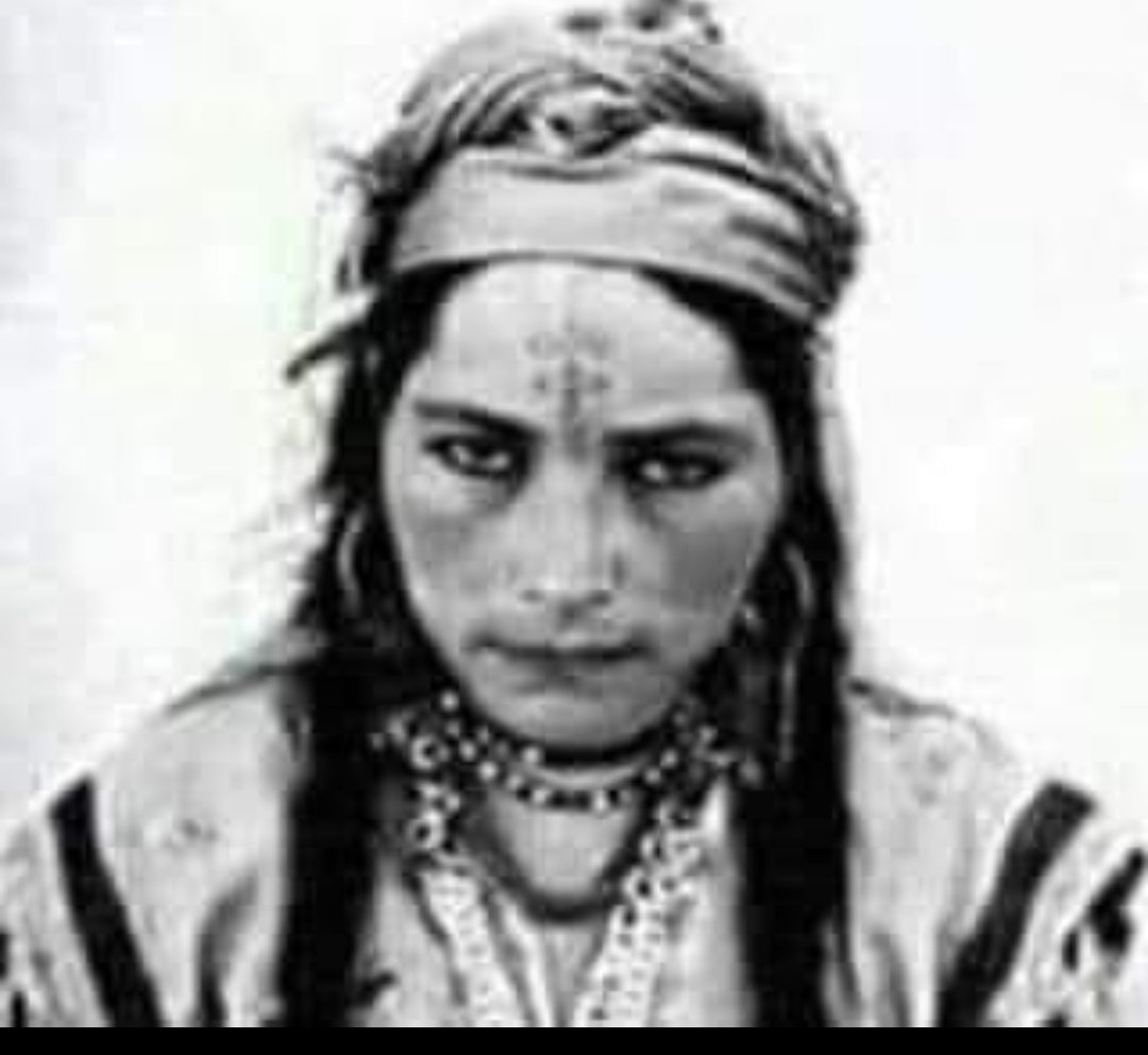 ahm_alnasser's tweet photo. هذه المرأة التي إبتكرت أسلوب جديد في حماية شرف النساء إبان الثورة الجزائرية حيث أنها كانت بمجرد سماع هدير سيارات العدو الفرنسي ... تصعد مباشرة إلي سطح منزلها وتصيح على النساء فيأتين إليها راكضات نحو الحوش ( فناء البيت ) 
الذي يستعمل لدرس الحبوب ( القمح والشعير ) حيث تجتمع الكثير من النسوة من سن 07 إلي 60 سنةفتمسك كل واحدة في يد الأخرى و يتحولن إلي كتلة بشرية واحدة و إذا حاول الجنود الفرنسيين سحب إمراة جميلة مسكت فيها أيدي عشرات النساء فيكون ذلك حائلا دون الإعتداء عليها كما انها إبتكرت عصير البصل الذي يوضع في زجاجات و ترش به المرأة جسدها عند إقتراب العدو ، كما تلطخ وجهها و أطرافها بالفحم المتراكم علي القدور المصنوعة من الطين ومن آثار دخان الحطب !
ولكن عندما أكتشف العدو الفرنسي بانها هي الممثلة للثورة في غياب الرجال قصدها ضابط جبان وحطم قفص صدرها بعقب رشاشه فأستمرت 3 أيام تتقيأ الدم إلي أن فرغ جسدها منه و لفظت أنفاسها شهيدة 
انها المرأة الحرة " غزالة بنت عمار "المصور الفرنسى الذى التقط هذه الصورة كتب فى مذكراته :
لم اخف فى حياتى كلحظة التقاط الصوره لهذه المرأة فى الاوراس !