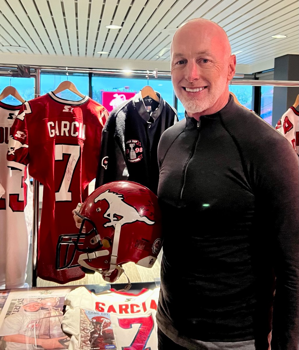 Jeff Garcia, QB of Calgary Stampeders 1998 Grey Cup championship team, poses with display of the memorable team at their 25th anniversary reunion at Stamps House on Friday. Jeff was MVP in 26-24 victory over Hamilton.