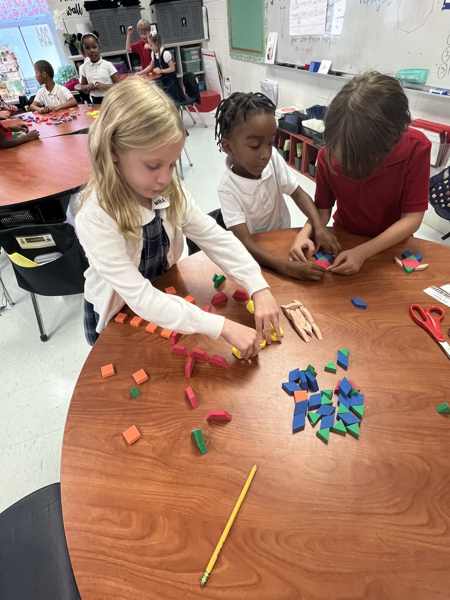 Golden2nd's tweet image. Students are learning all about triangles, quadrilaterals, pentagons, and hexagons. After sorting shapes and naming the number of vertices students created pictures as a collaborative team.  @MaryBAustin ##AimForExcellence #LearningLeading