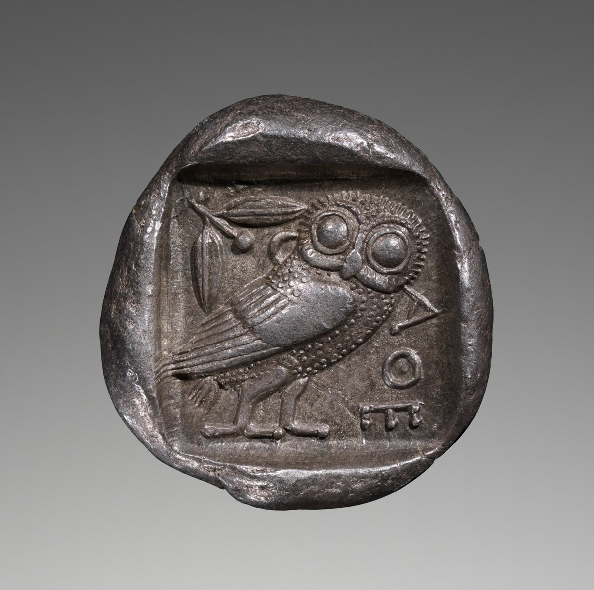 An Athenian silver tetradrachm ca. 475–465 B.C., showing Athena's owl and an olive branch. Collection: The Getty.