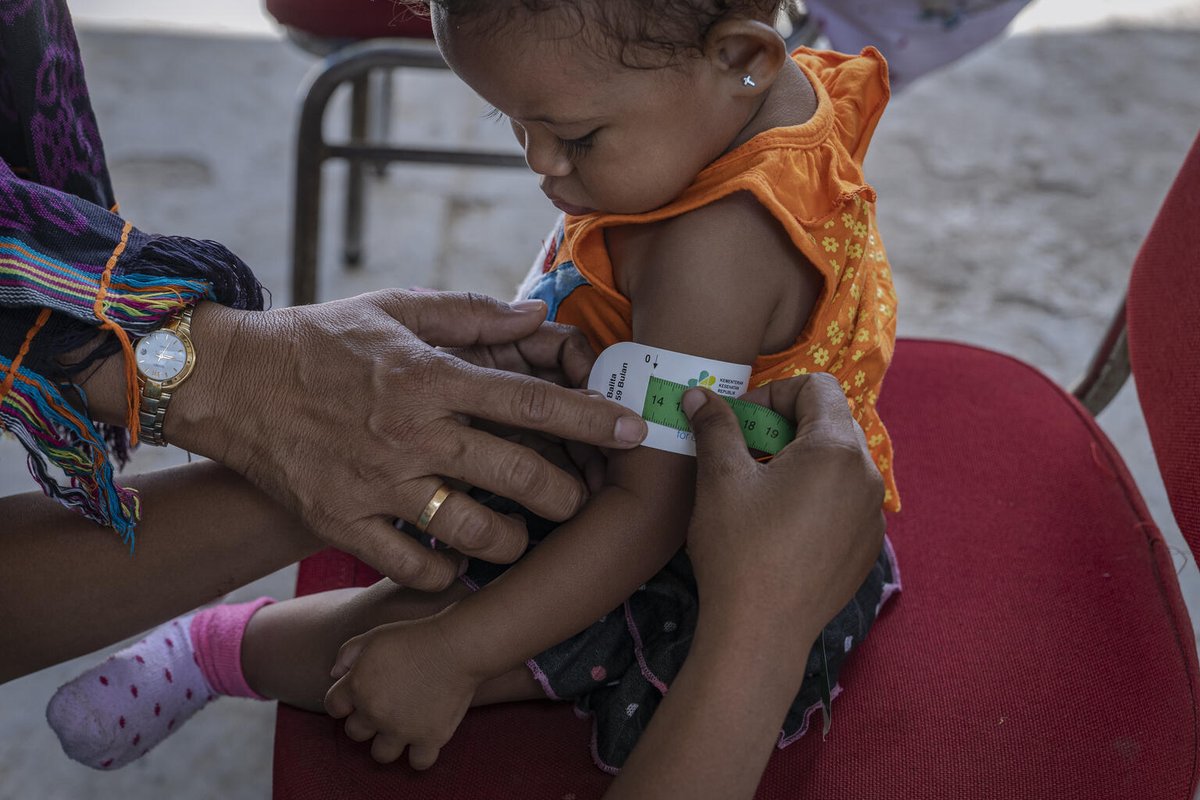 Seorang ibu sedang mengukur lingkar lengan atas anaknya menggunakan pita LiLA di Posyandu di Kupang, Nusa Tenggara Timur.