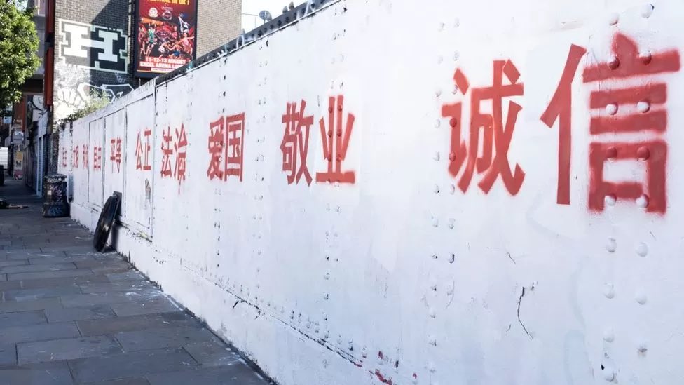 作为艺术类工作者
客观讲
这个老同志先要搞清楚
这次喷的标语
真的蛮符合波普精神的
这个不敢露脸的年轻小女孩艺术家应该要明白，当这个标语放置的位置决定并且赋予了整件作品的精神内核，东西方文化政治的碰撞，而且造成这么大的舆论影响，侧面证明了，这是件非常有社会讨论性的行为艺术作品
所以🤷，抛开政治不谈
这个行为真挺艺术的