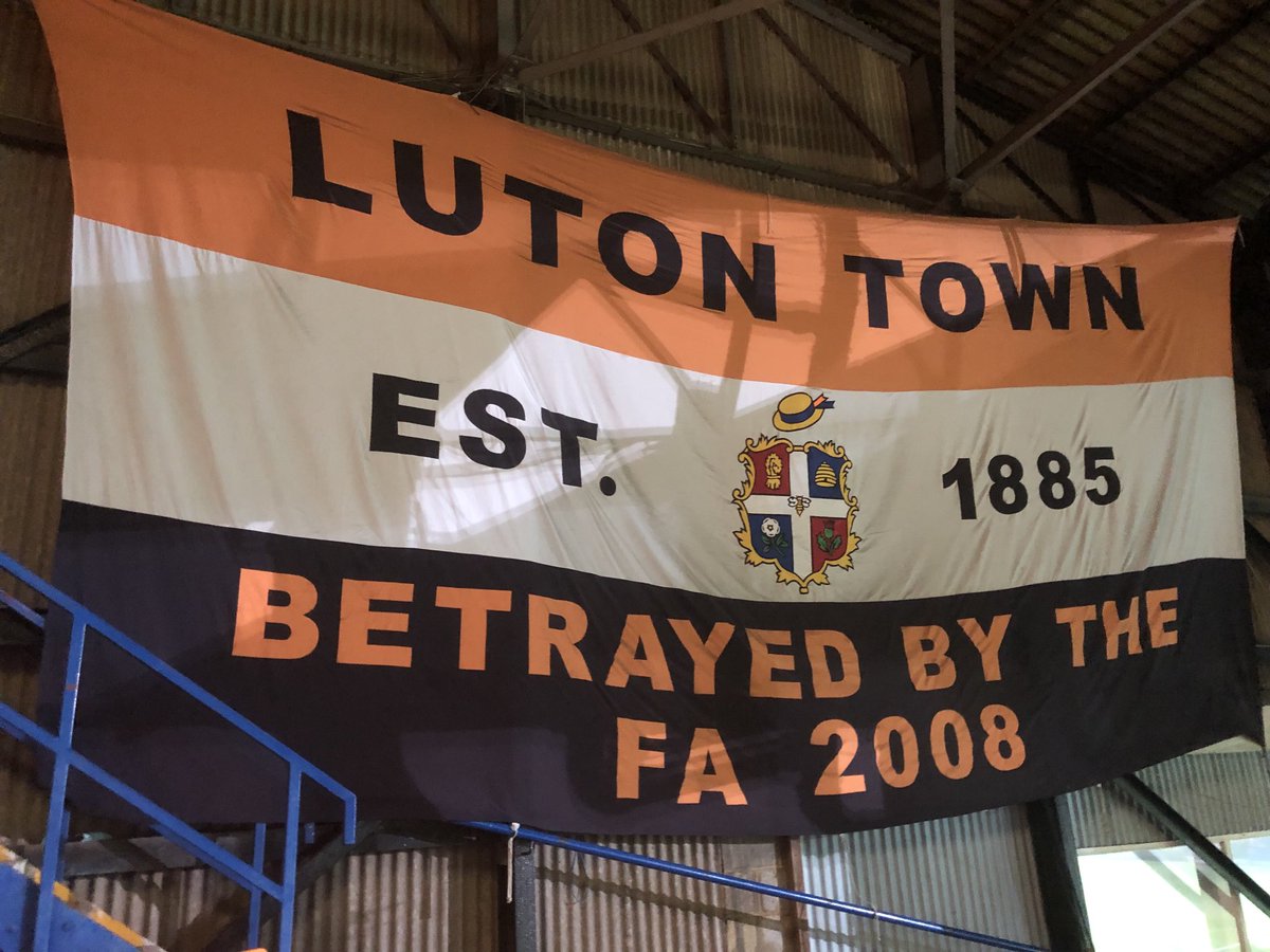 henrywinter's tweet photo. Famous #LTFC fans’ flag will continue to hang at Kenilworth Road this season. Powerful reminder of the importance of fans keeping a club alive against all odds. And look at them now - @premierleague 🙌🎩 https://t.co/yt7vKW1Ih8