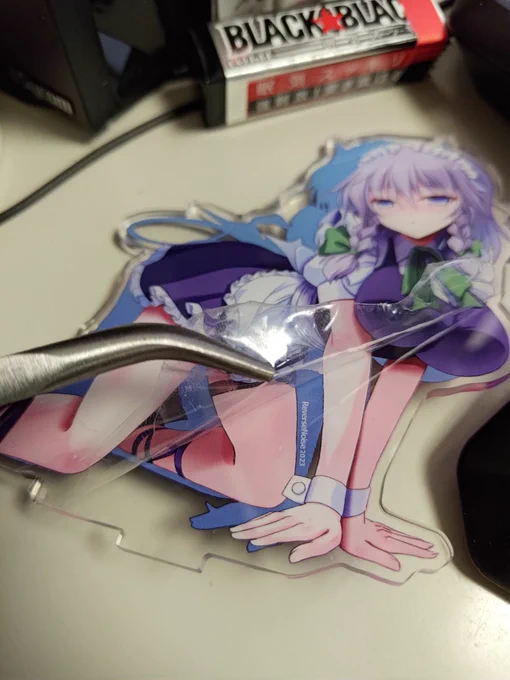 アクスタは表面が保護フィルムに覆われてます。こんな感じで剥がれるよ。結構剥がしづらいけど端のところを適当に爪で引っ掛ける感じで。あ、表面(ひょうめん)ね、今回のは表裏両側にフィルムが貼られてますw 
