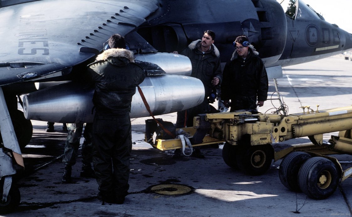 HarrierPres's tweet photo. 1983, ground crews load Napalm canisters under the wings of an AV-8C during a weapons training camp in the Nevada ranges. #AV8C #USMCHarrier #Harrierpres #AV8A https://t.co/wITXq16o1u