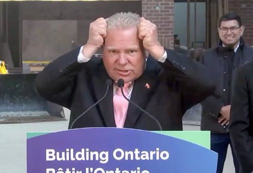 Doug Ford pictured today explaining to reporters how he put his thinking cap on to try to come up with a solution to Ontario’s housing shortage.