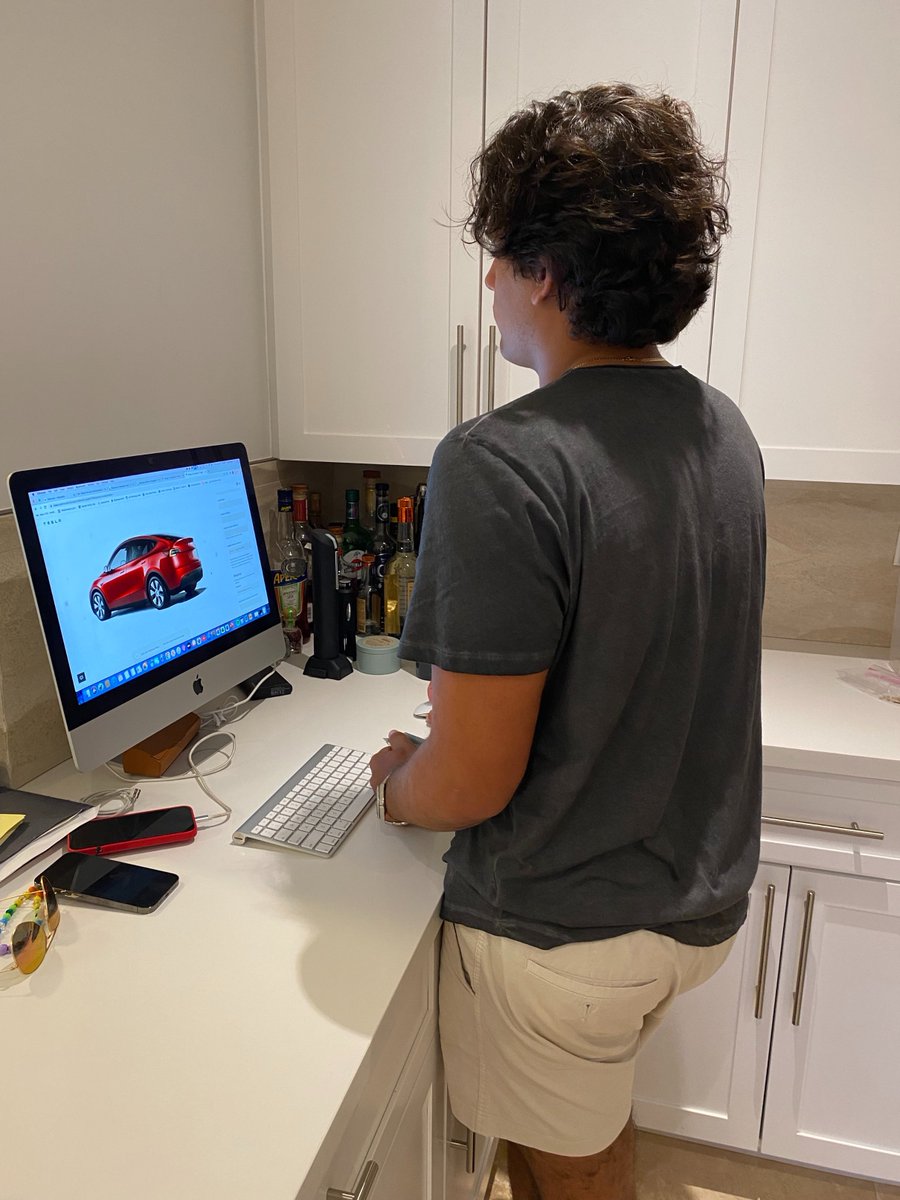 This is my grandson figuring out what Tesla I should buy, notice the color...he escorted me to the dealer and walked me through the process and was patient with me. Send him a kiss for being so sweet! #buyingacar #buyingaTesla #family #Redcar