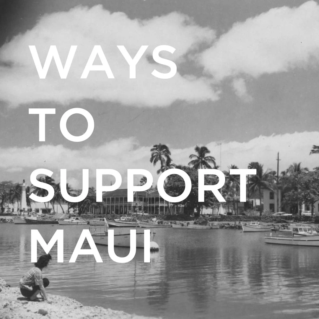 black and white square image of historic Lahaina town before the wild fire. Boats and buildings are seen in the background along with palm trees. In the foreground is a woman kneeling on the shore, facing the water. White text over the photo reads, "Ways to support Maui"
