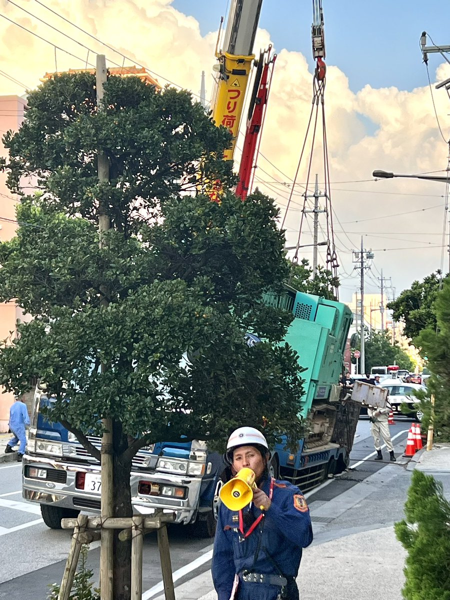 landlord373's tweet photo. 宜野湾コンベンションシティ横の道路���トレーラーの重さで道路陥没。大渋滞と通行止めで何かと思いました。
見るからに重そうなものを積んでいるトレーラー。積載量オーバーなのか、この間の台風で道路がダメージ受けていたのか。怪我人はいなそうで良かったですね
#事故　#道路陥没 https://t.co/LQsPYhSVNP