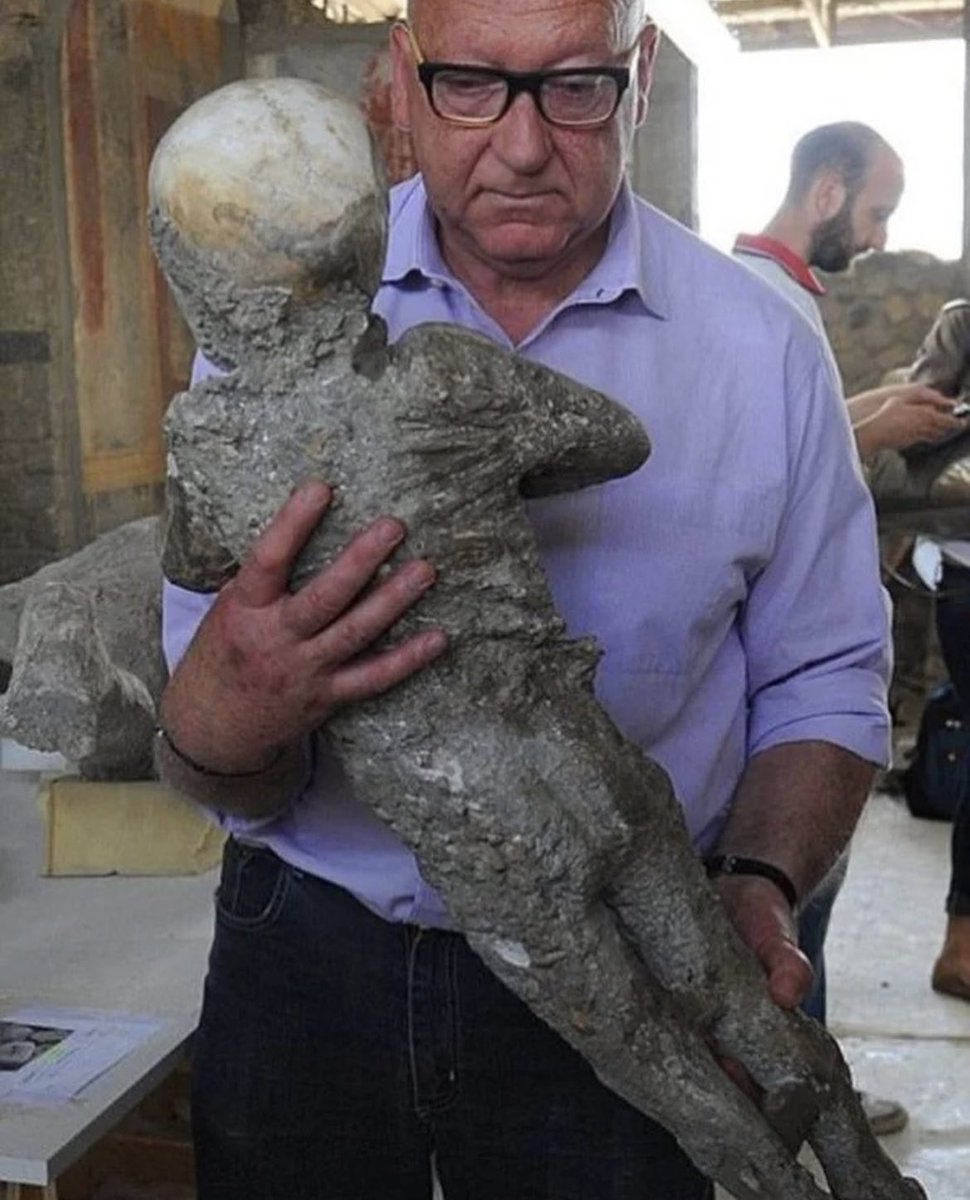An archaeologist holds a plaster cast of a child's body that died as a result of the eruption of Vesuvius in 79 CE in Pompeii. The child was sitting on his mother's lap when the tragedy struck. It is believed that he was about four years old.

Most of the inhabitants of Pompeii