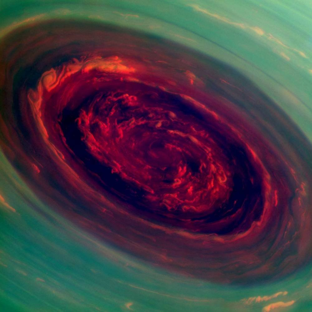 Cette image vous présente une rose céleste. Au pôle nord de Saturne, des vents à ~500km/h créent cet immense tourbillon, capturé en infrarouge par la sonde Cassini. Cette image en fausse couleur nous montre les nuages de basse altitude (rouge) et ceux de haute altitude (vert)