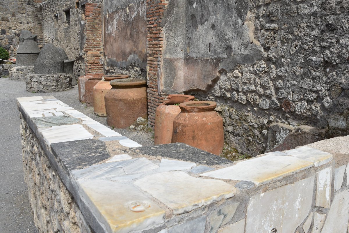 pompeii_sites's tweet photo. Often associated with the ovens and mill rooms were kneading rooms that contained a counter on which the dough was prepared for baking. Evidence of kneading machines has also been found as have containers for the grain that once had their volume inscribed on their rims. https://t.co/ooKSg6EJ0O