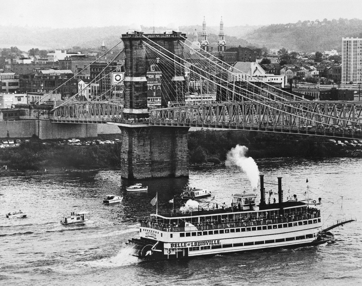 The Belle of Louisville going under the Roebling Bridge. 1960s. Cincinnati.